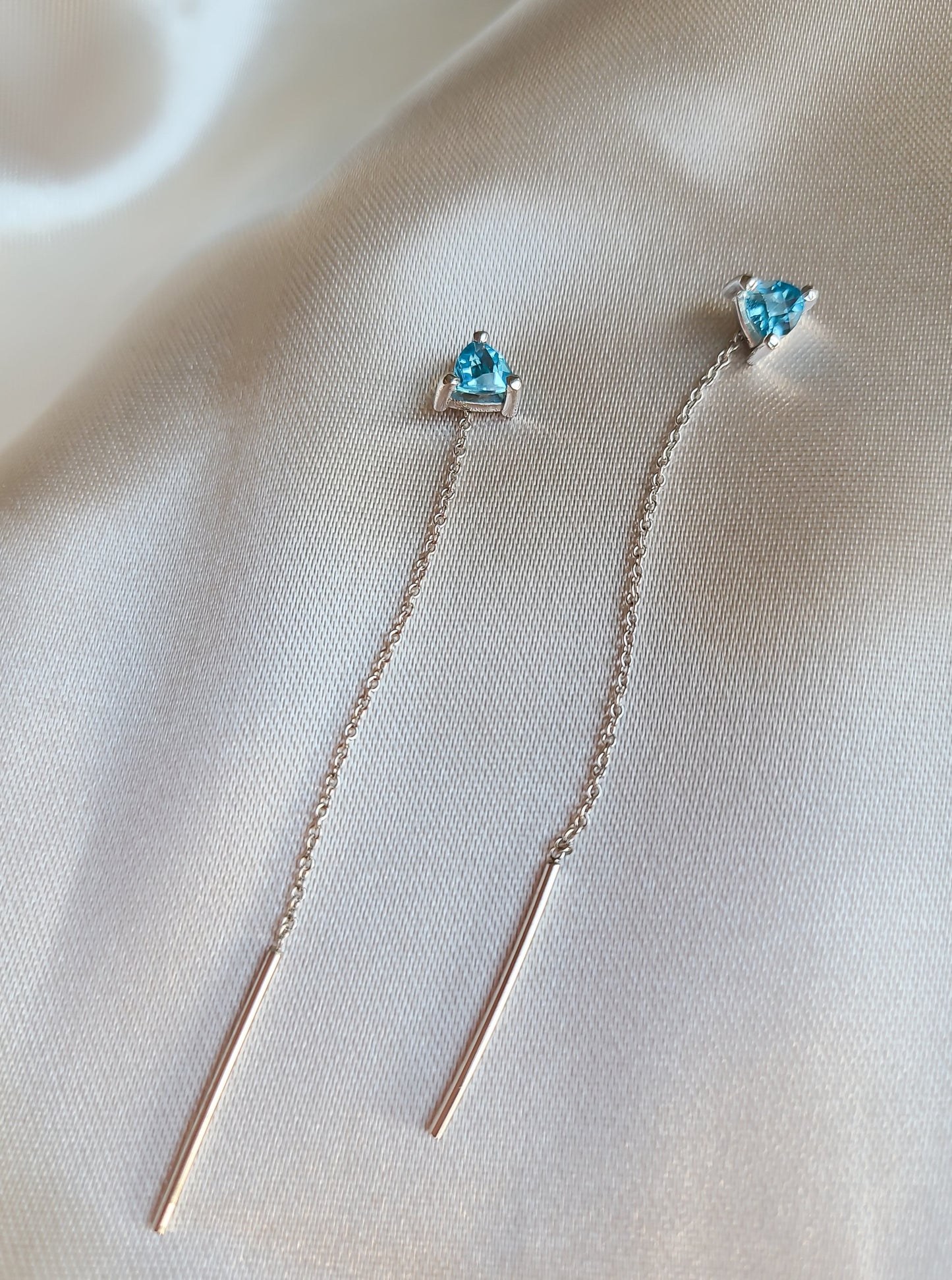 Falling earrings with vivid blue trilliant topaz in 14K white gold