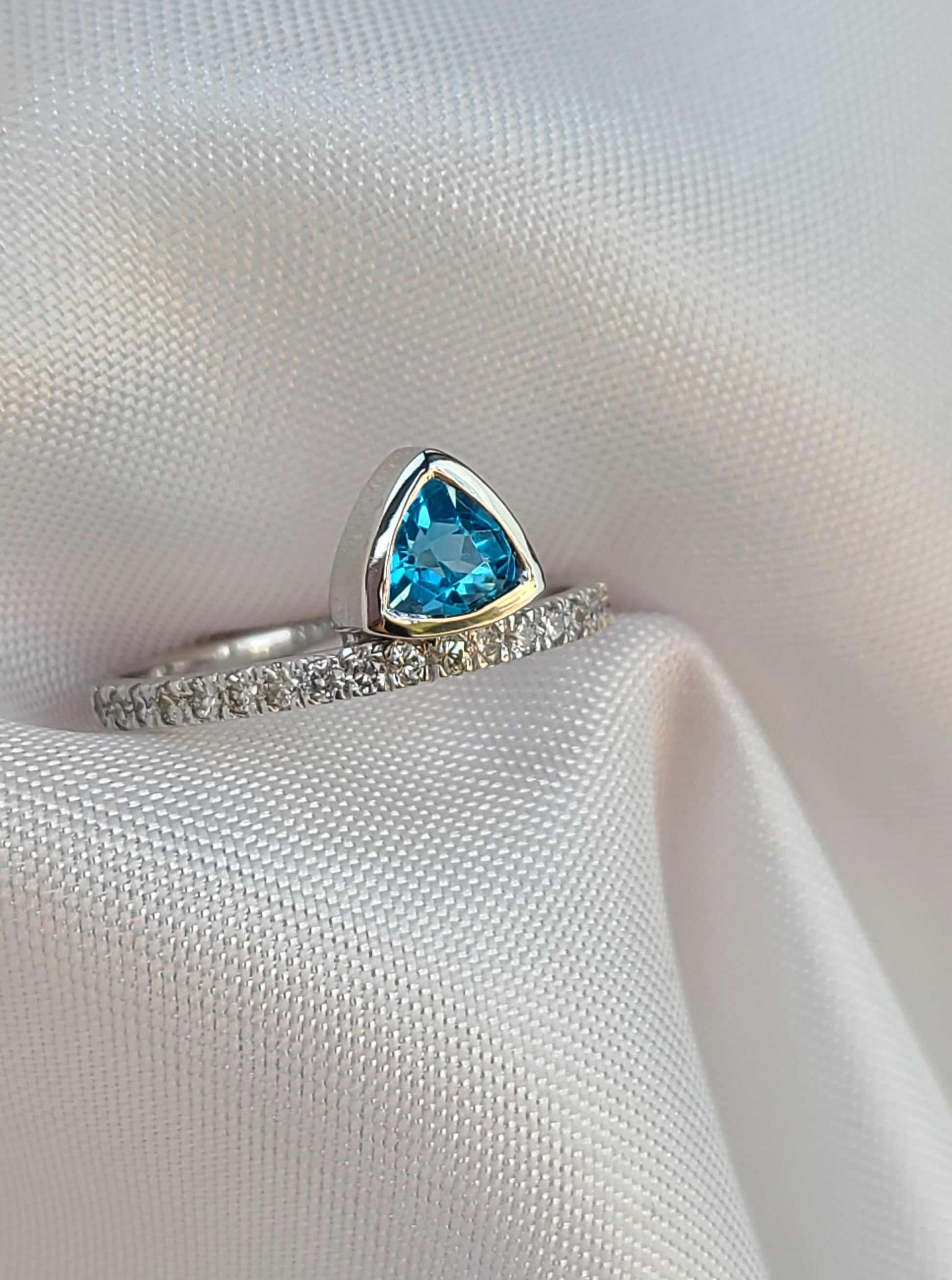 Floating vivid blue trilliant topaz gemstone ring in 14k white gold