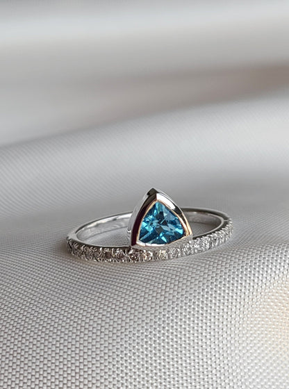 Floating vivid blue trilliant topaz gemstone ring in 14k white gold