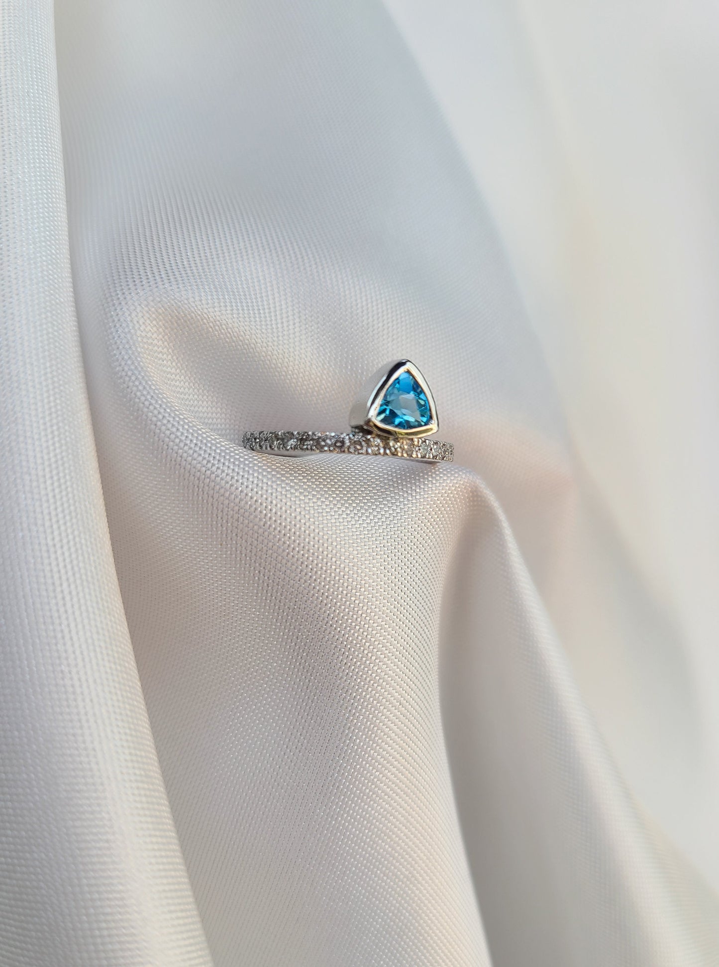 Floating vivid blue trilliant topaz gemstone ring in 14k white gold